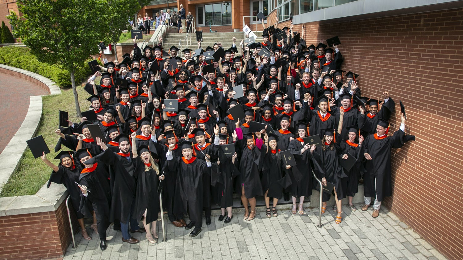 A group photo of NC State Master of Science in Analytics graduates on the steps of Talley Student Union.